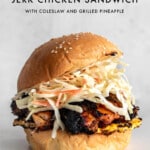 Jerk chicken sandwich with pineapple and coleslaw with recipe title and logo.
