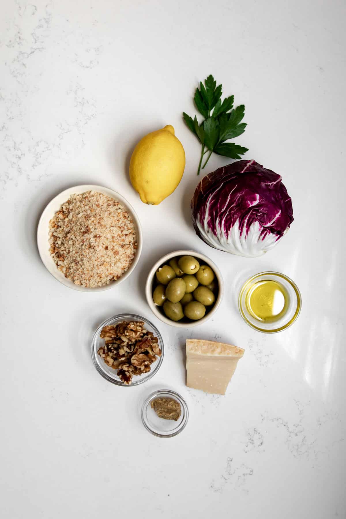Ingredients needed to make Radicchio Salad with Lemon Parmesan Dressing arranged on table.