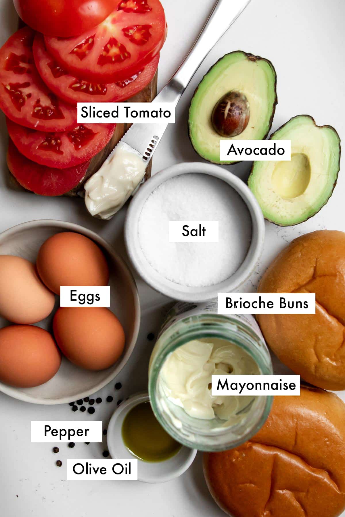 Ingredients needed to make a fried egg sandwich on a marble counter.