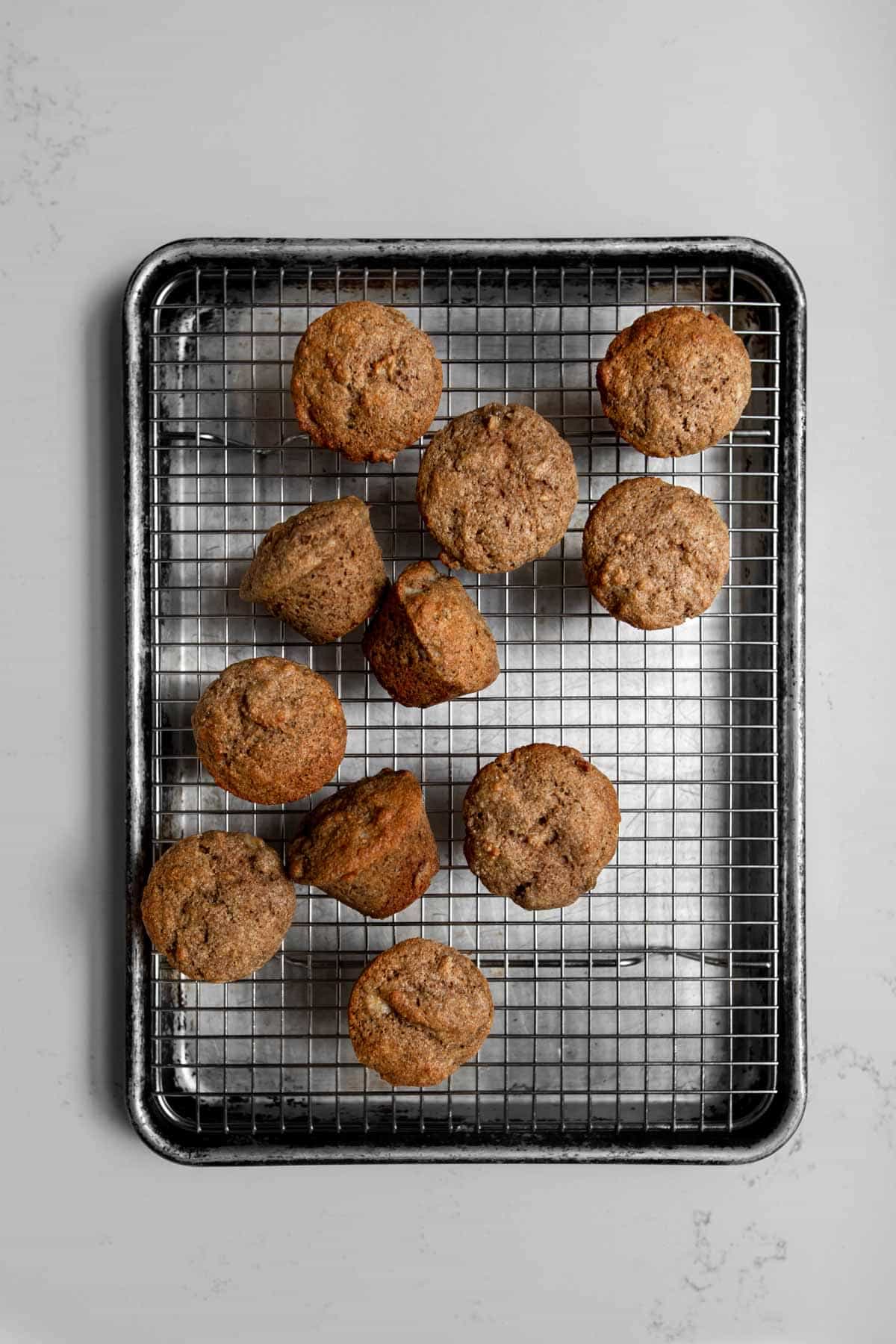 multtiple mini banana muffins out of the oven and cooling on a wire rack.