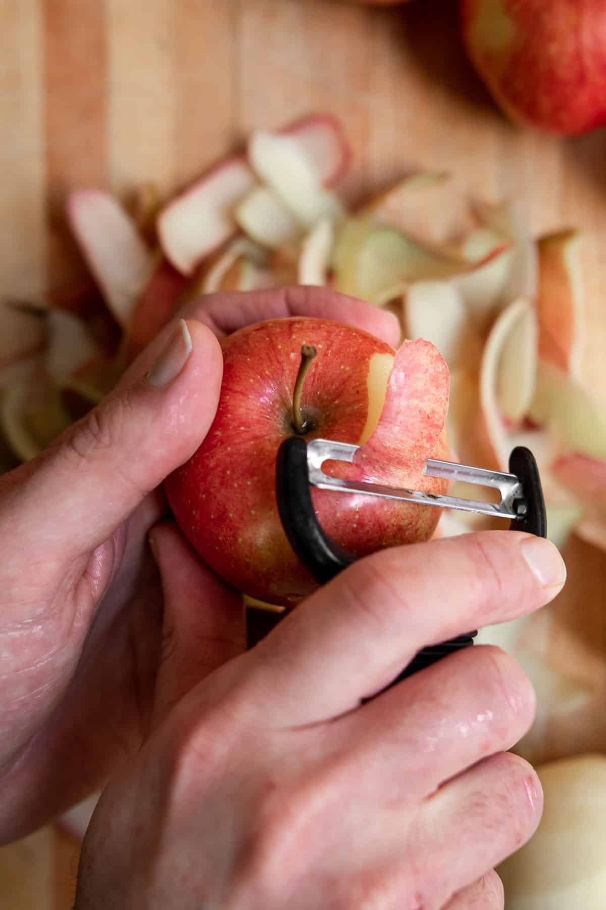 hand peeling apples with a peeler.