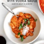 creamy gnocchi with vodka sauce in a bowl with a fork with text graphic.