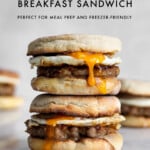 Two sausage breakfast sandwiches on an english muffin stacked on top of each other with yolk running down with text graphic.