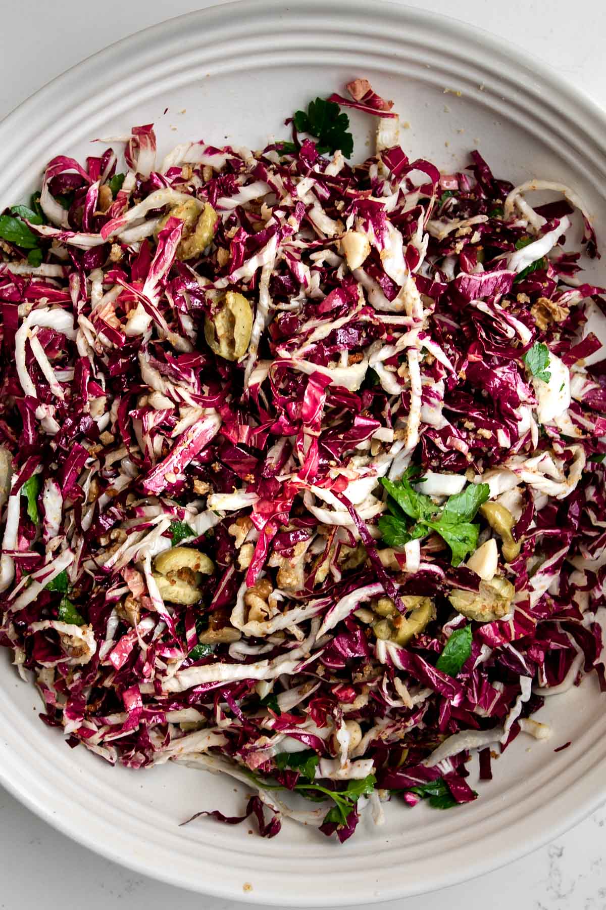 radicchio salad topped with olives, walnuts and parsley.