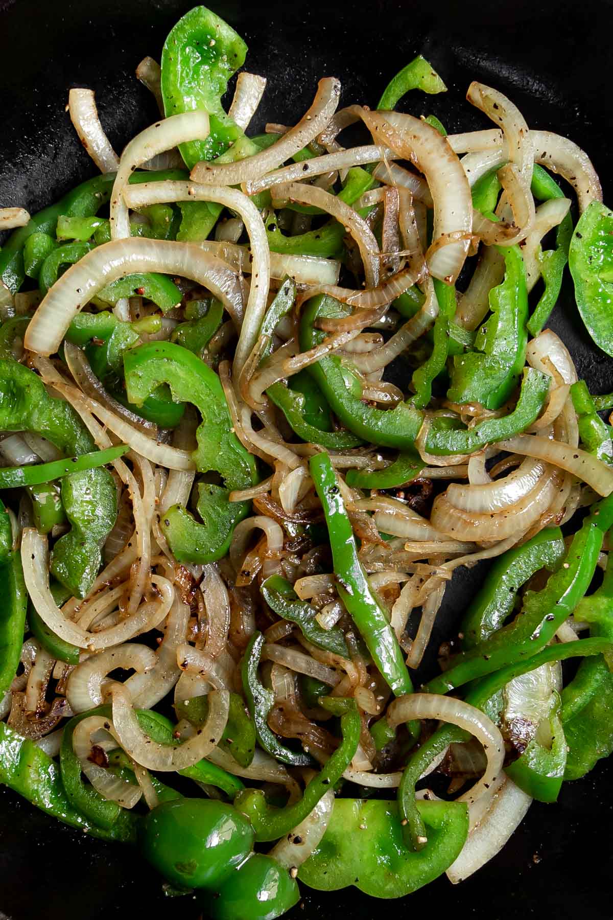 Grilled onions and green peppers in a skillet.