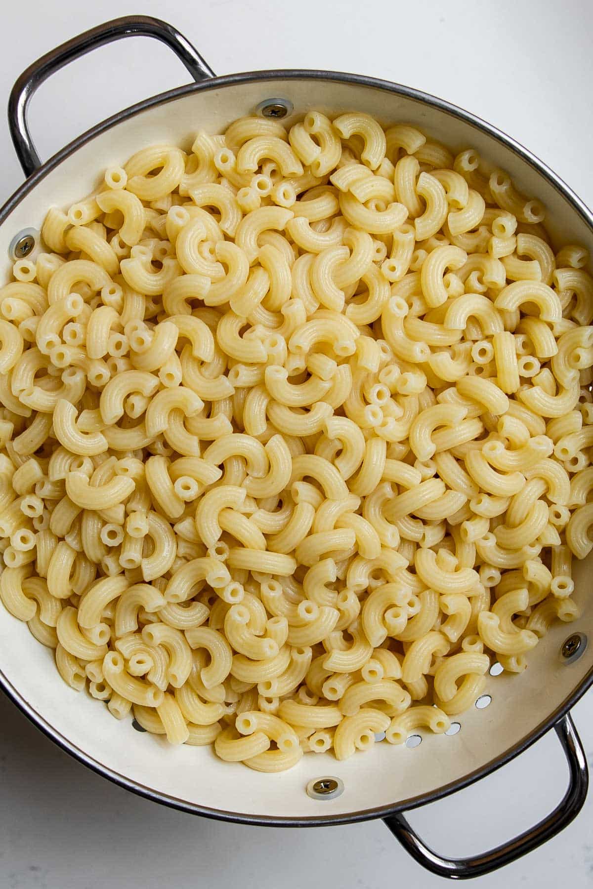 cooked macaroni noodles in a colander.