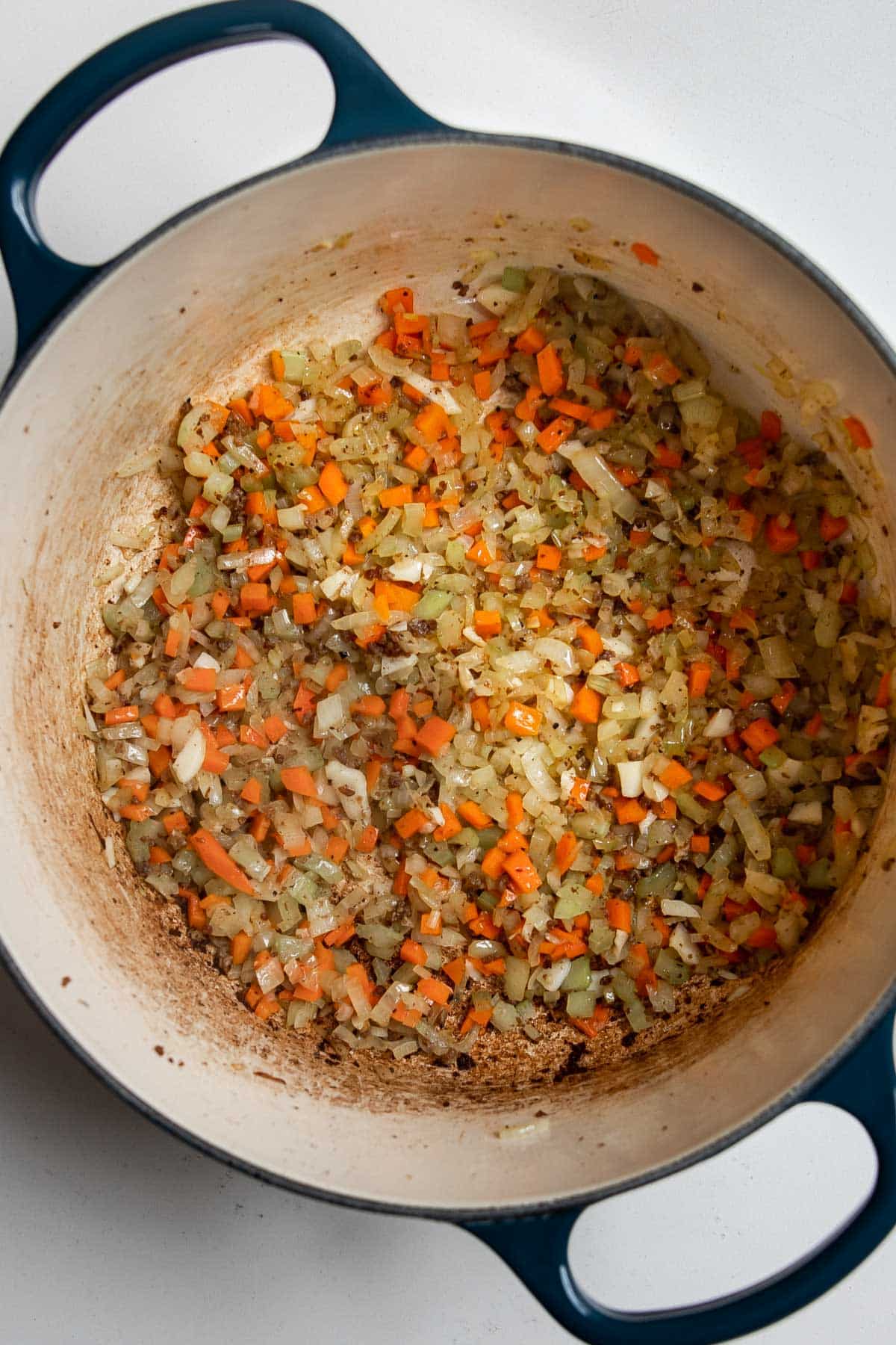 cooked mirepoix of carrot, onion and celery in a pot.