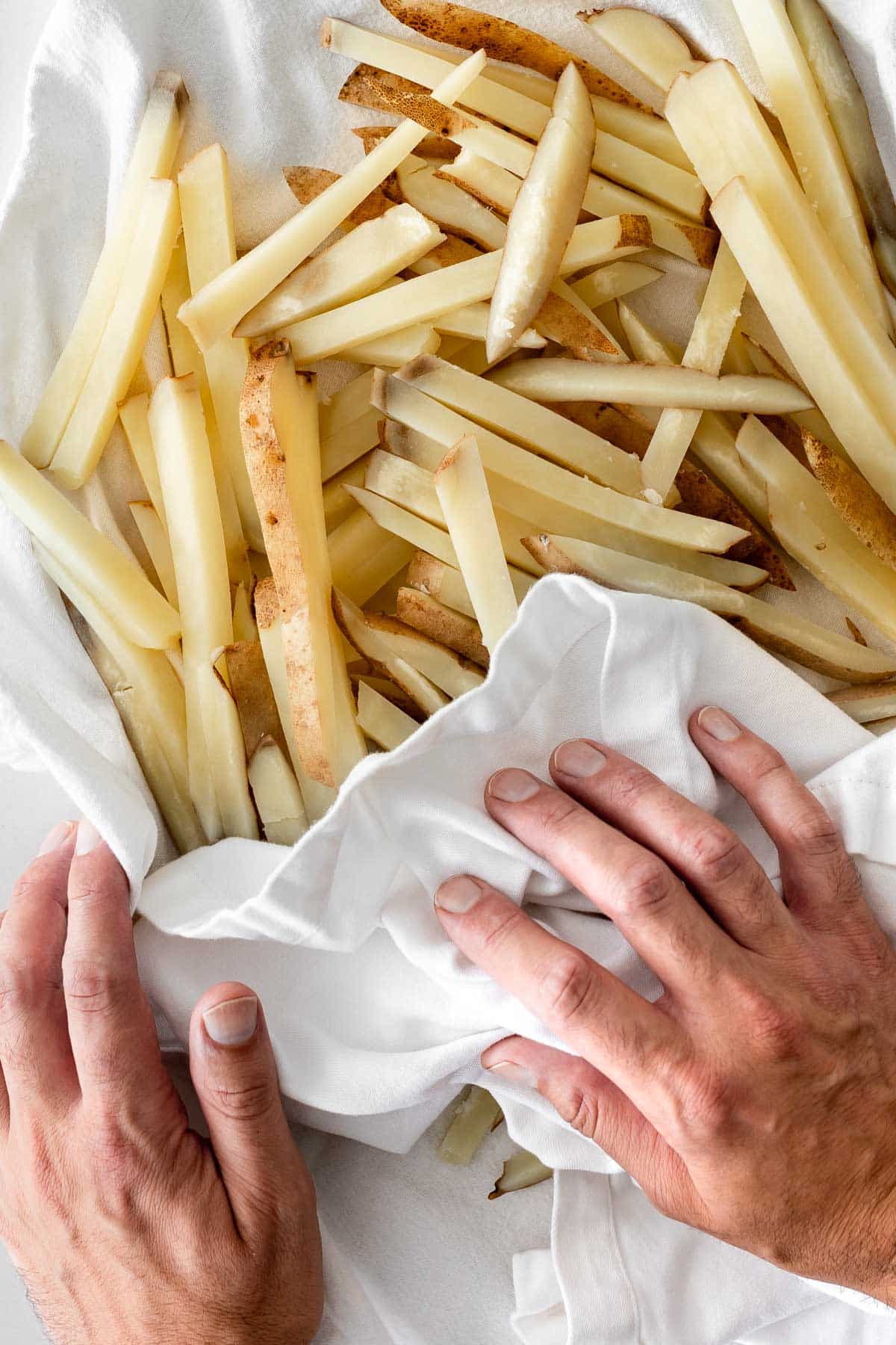 par-boiled french fries being dried in a towel.