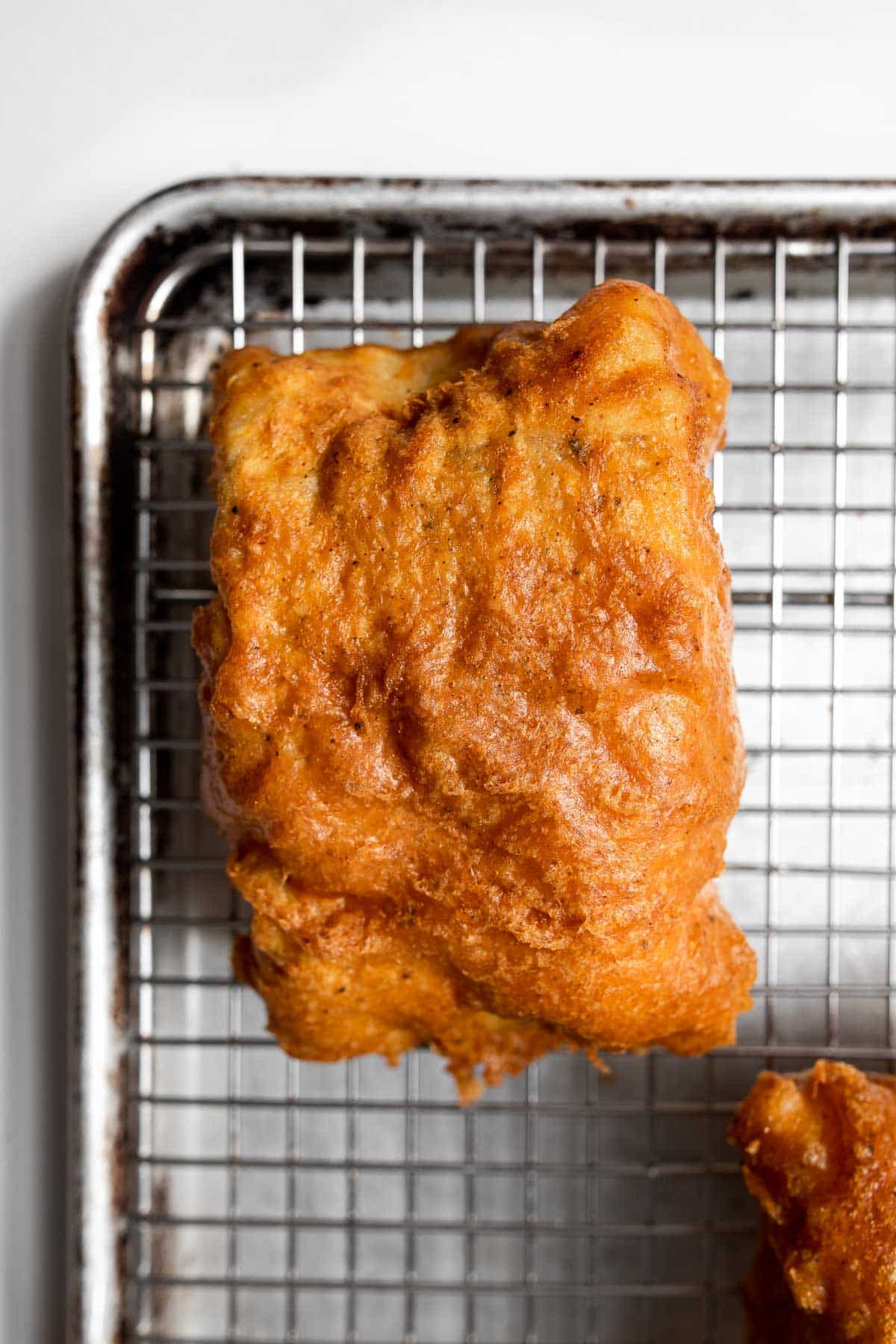 fried cod on a wire rack.