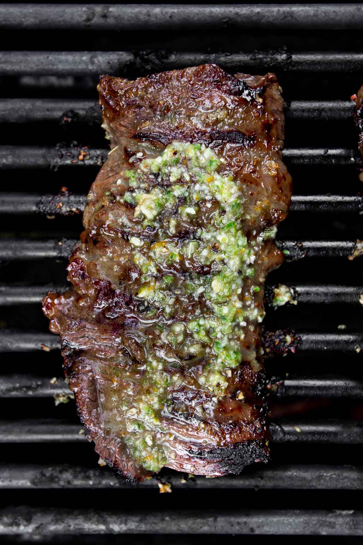 skirt steak on barbecue with carne asada marinade on top.
