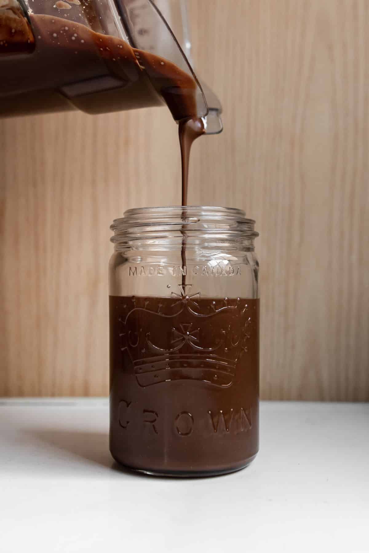 chocolate hazelnut spread being poured into a mason jar.