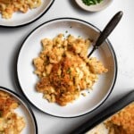 old fashioned baked macaroni and cheese in a bowl with a fork with chives on top.