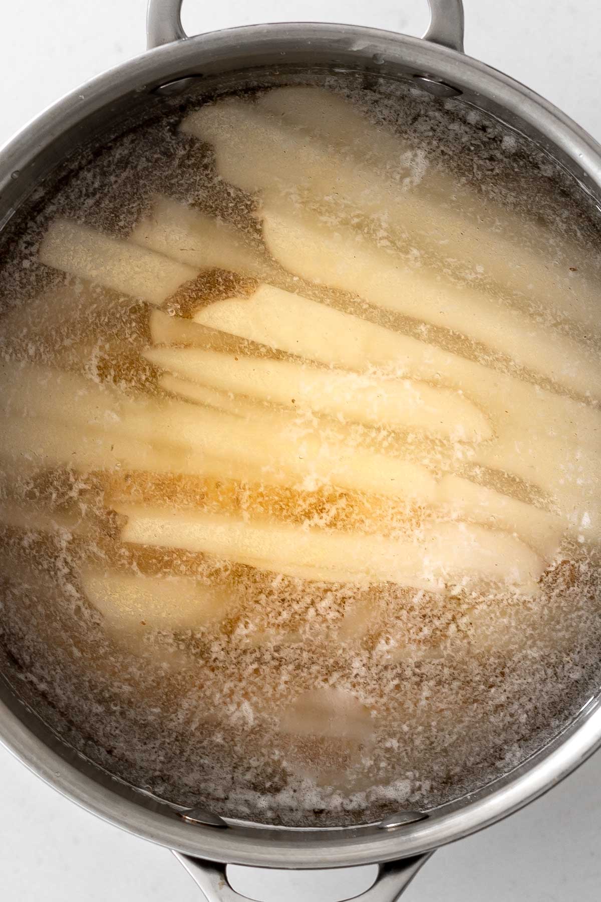 potato strips in a pot of water.