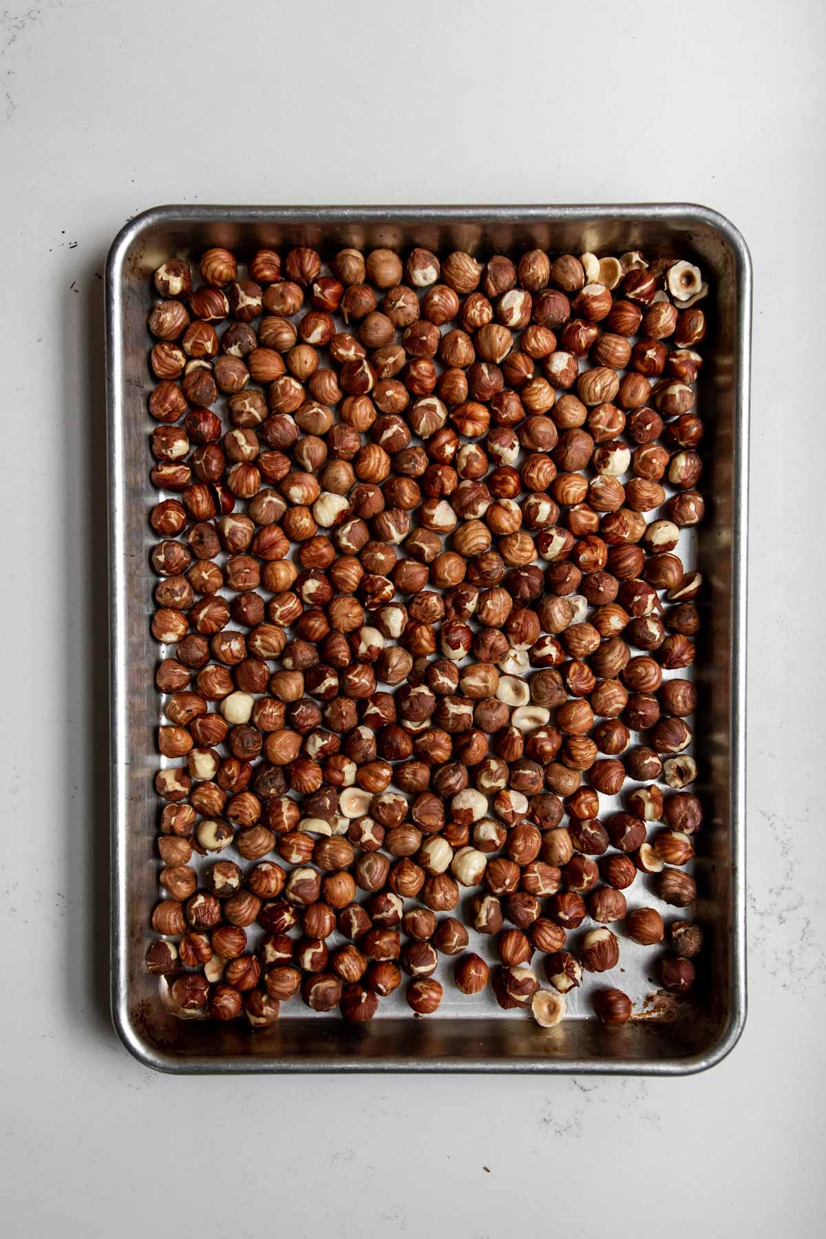 roasted hazelnuts on a sheetpan.