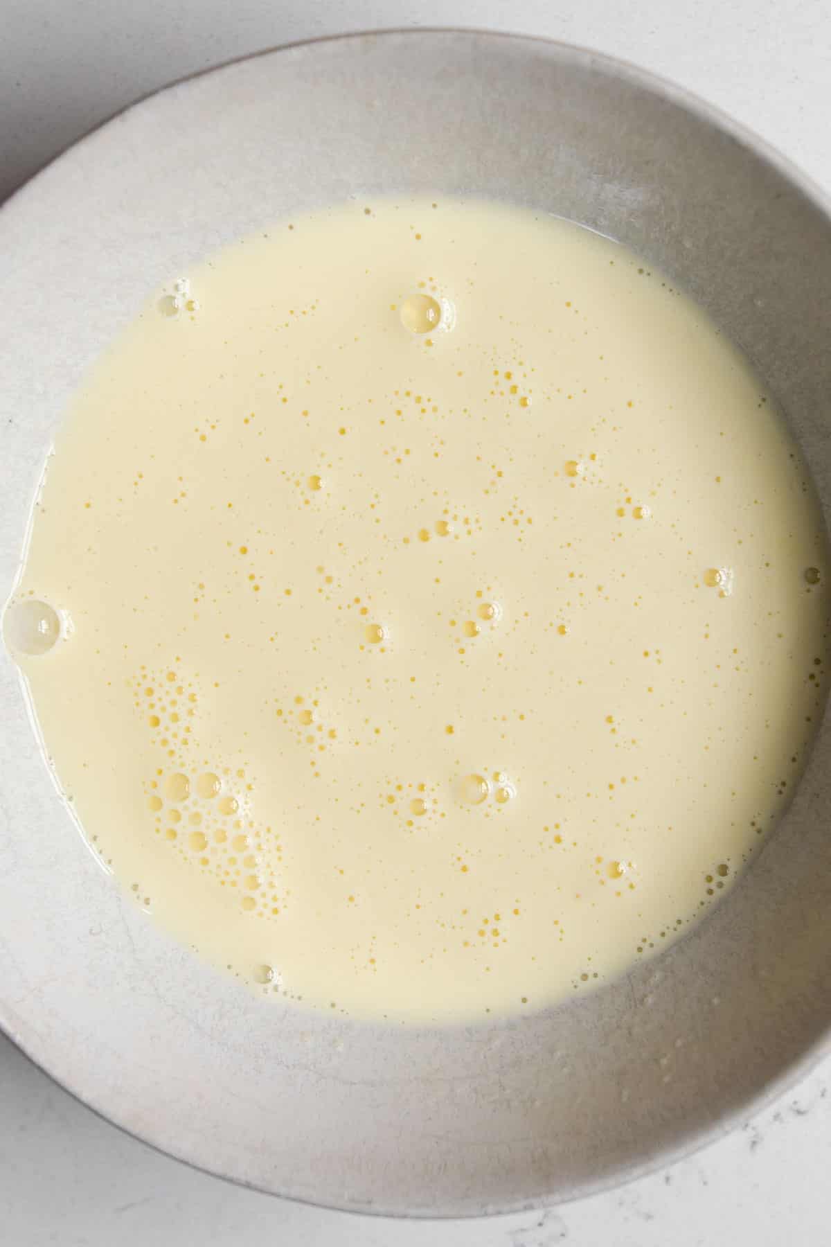 egg and cream whisked together in a bowl.