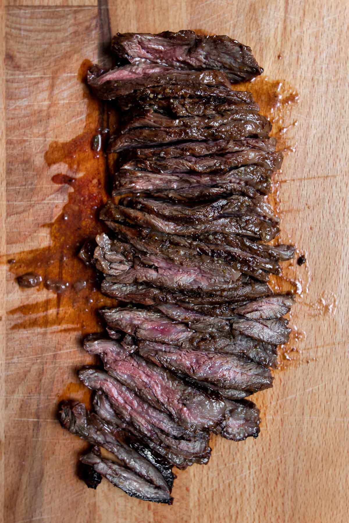 Grilled and sliced skirt steak on a cutting board.
