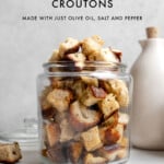 close up of sourdough croutons in a clear glass jar filled to the top with text graphics.