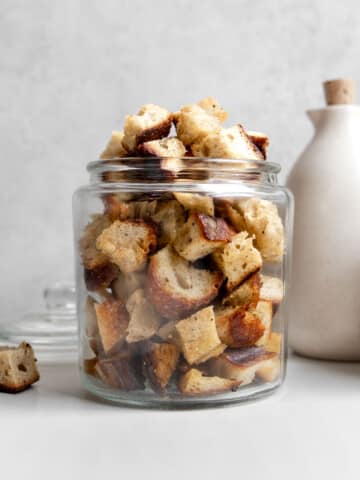 sourdough croutons in a clear glass jar filled to the top.