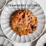 Strawberry scones with chocolate chunks on a plate on marble counter and text graphic.