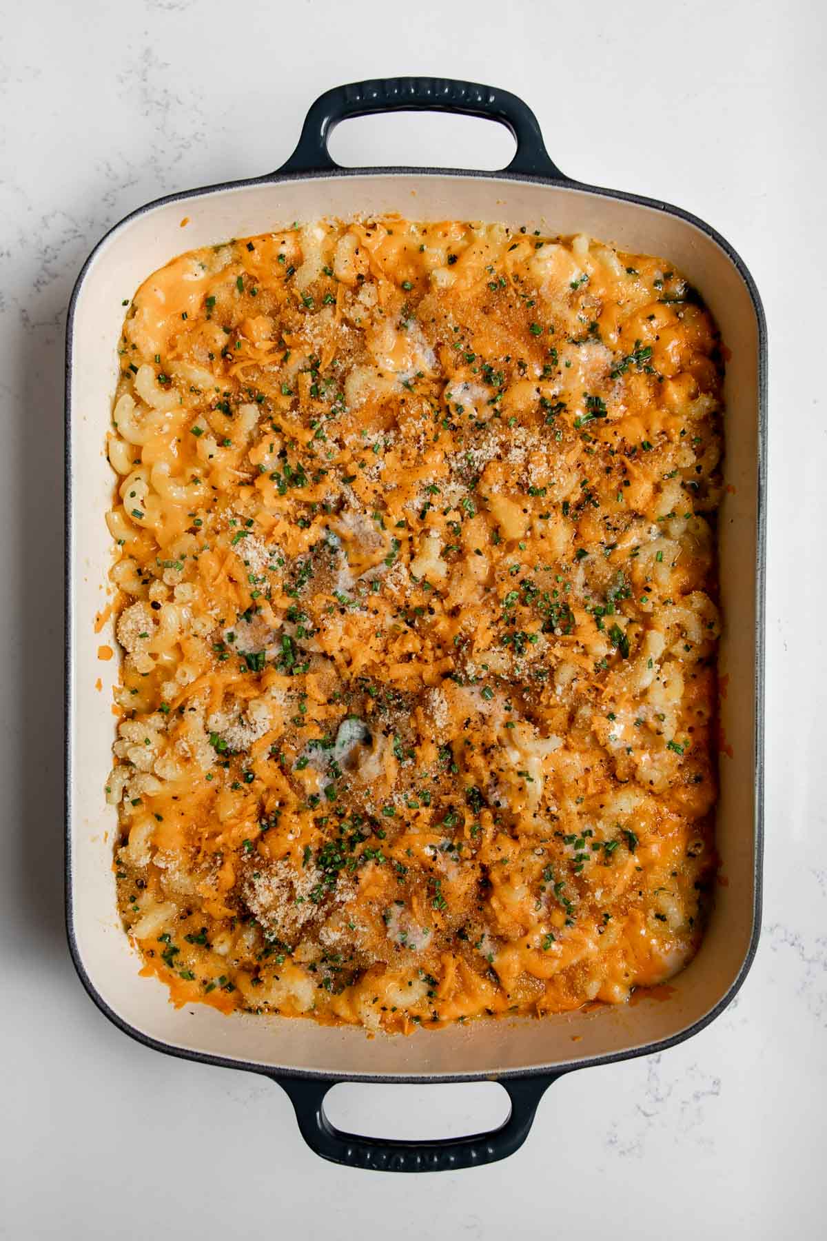 macaroni and cheese in a cast-iron pan out of the oven baked with cheese.