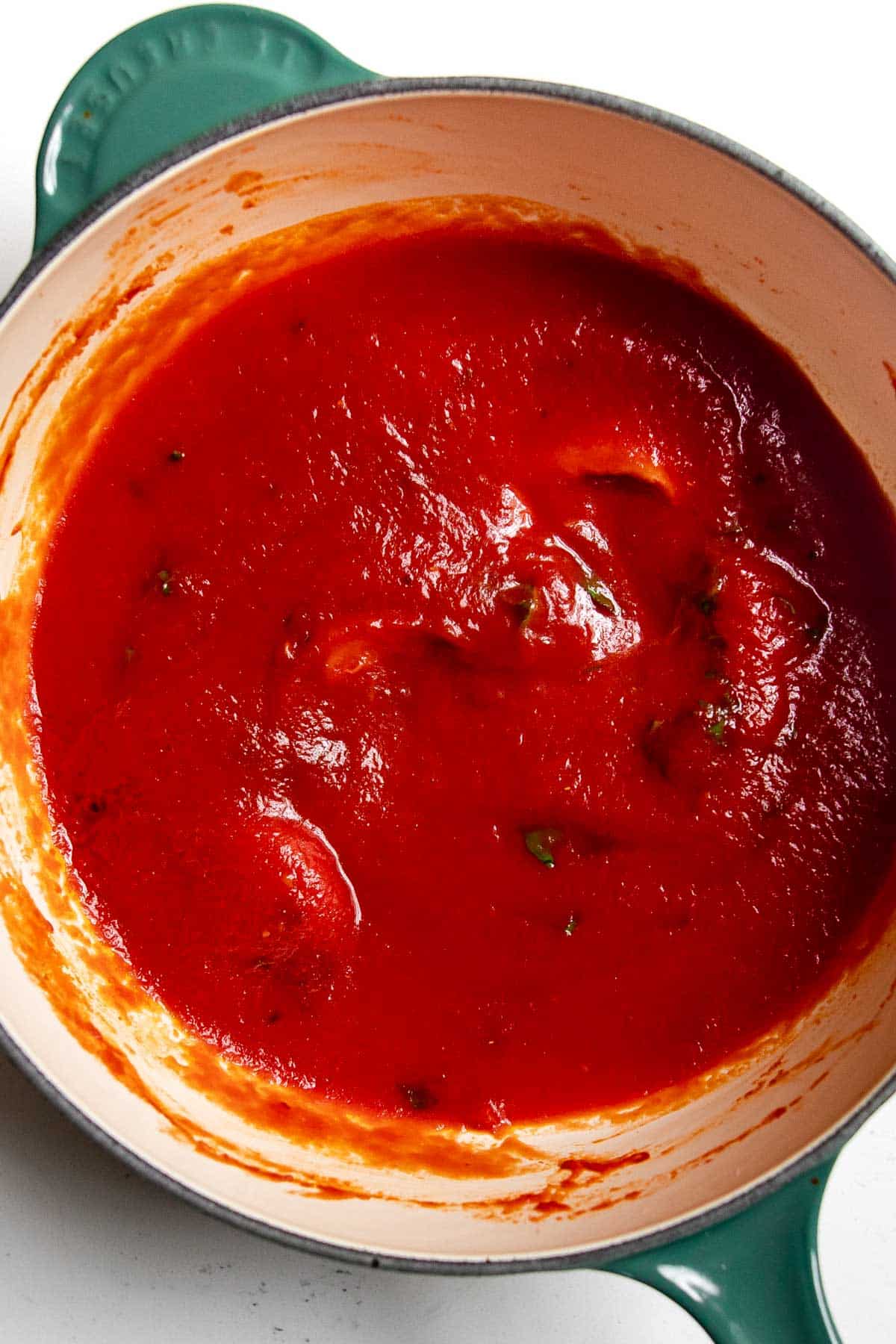 tomato sauce, garlic and basil in a pot.