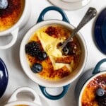 lemon créme brûlée topped with blueberries and blackberries cracked open with a spoon.