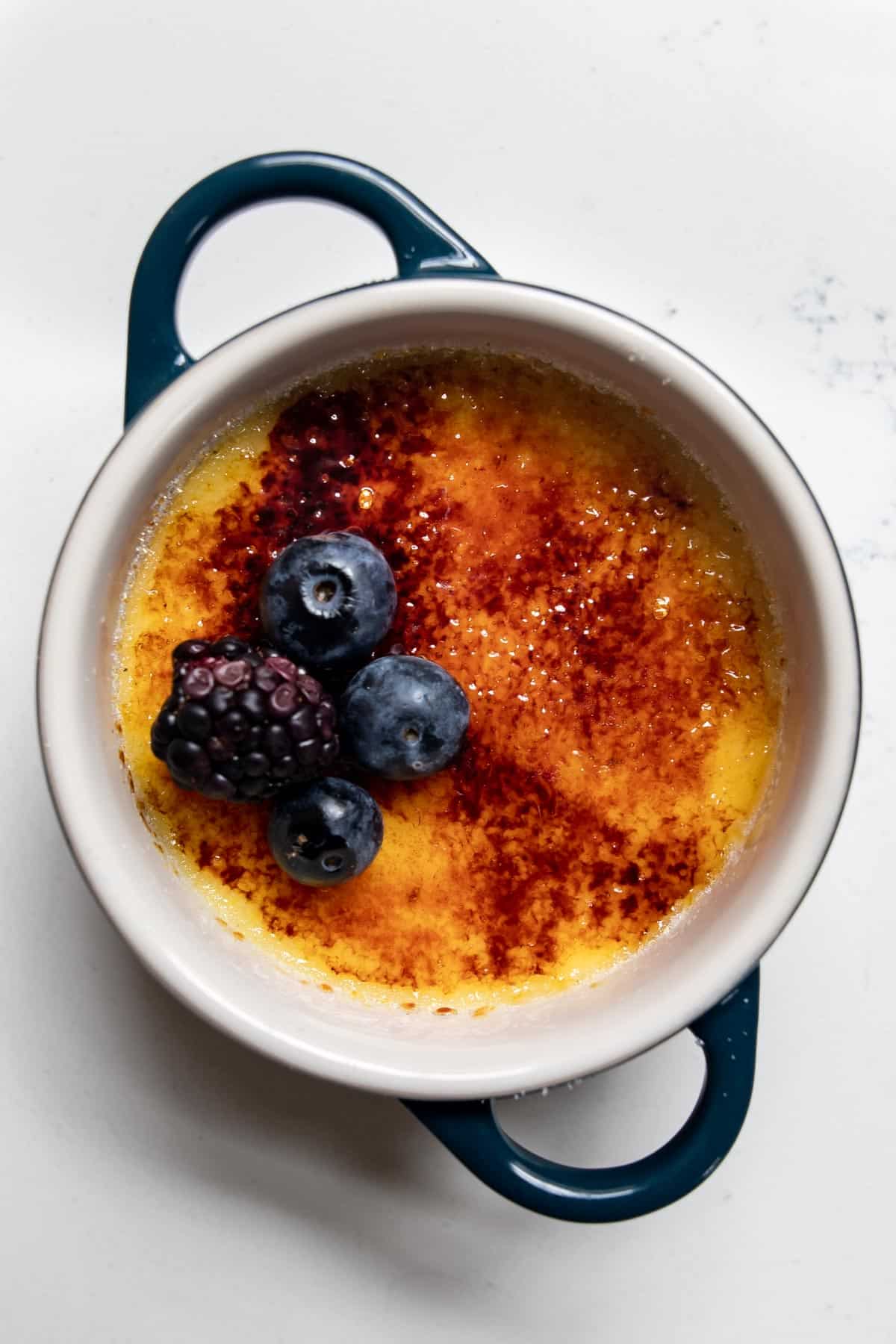 lemon creme brulee topped with blueberries and black berries.