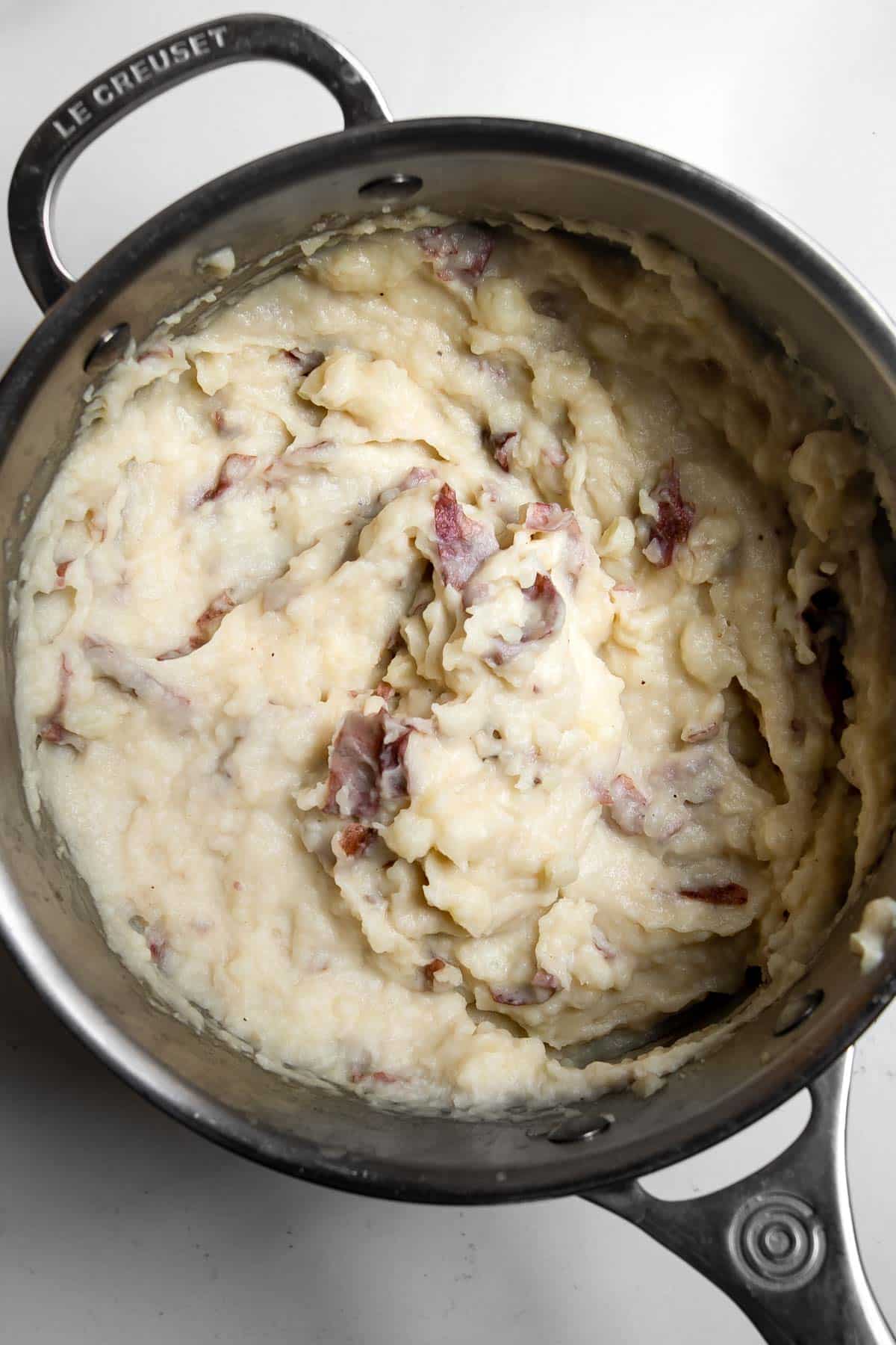 red skin potatoes mashed in a pot.