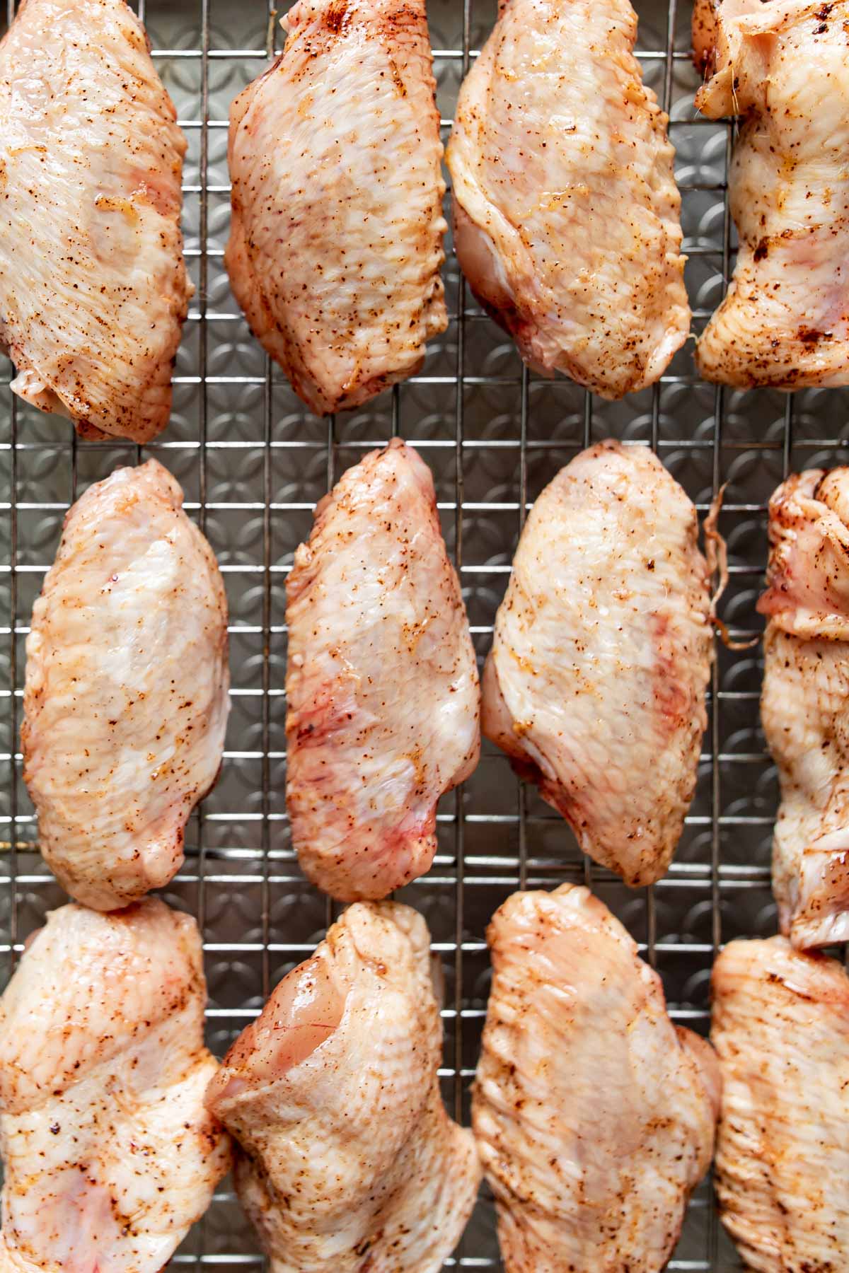 raw chicken wings drying on a wire rack.