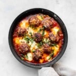 spicy meatballs with marinara sauce, baked mozzarella and fresh basil in a cast-iron skillet.