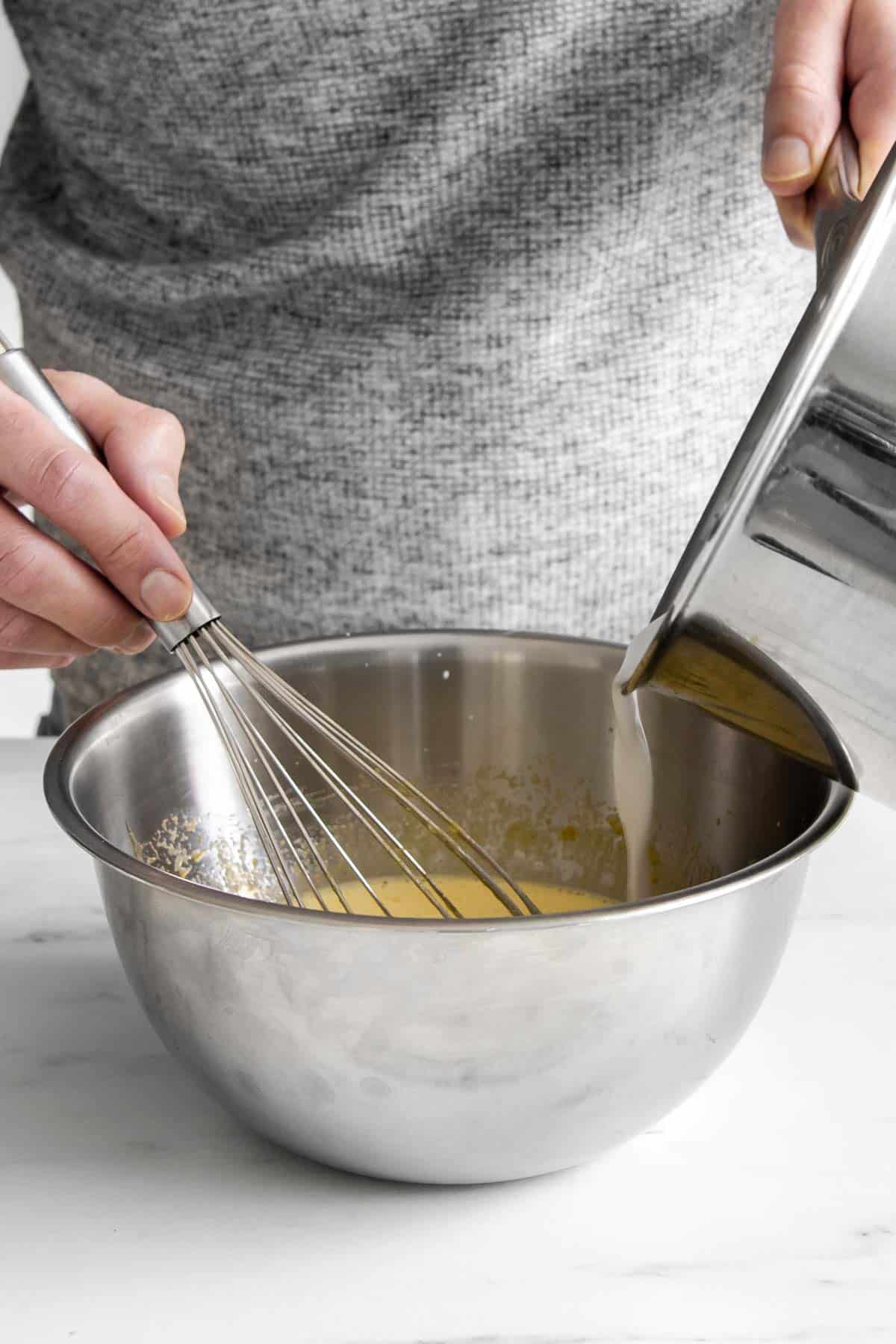 tempering a pot of hot coconut milk into eggs.