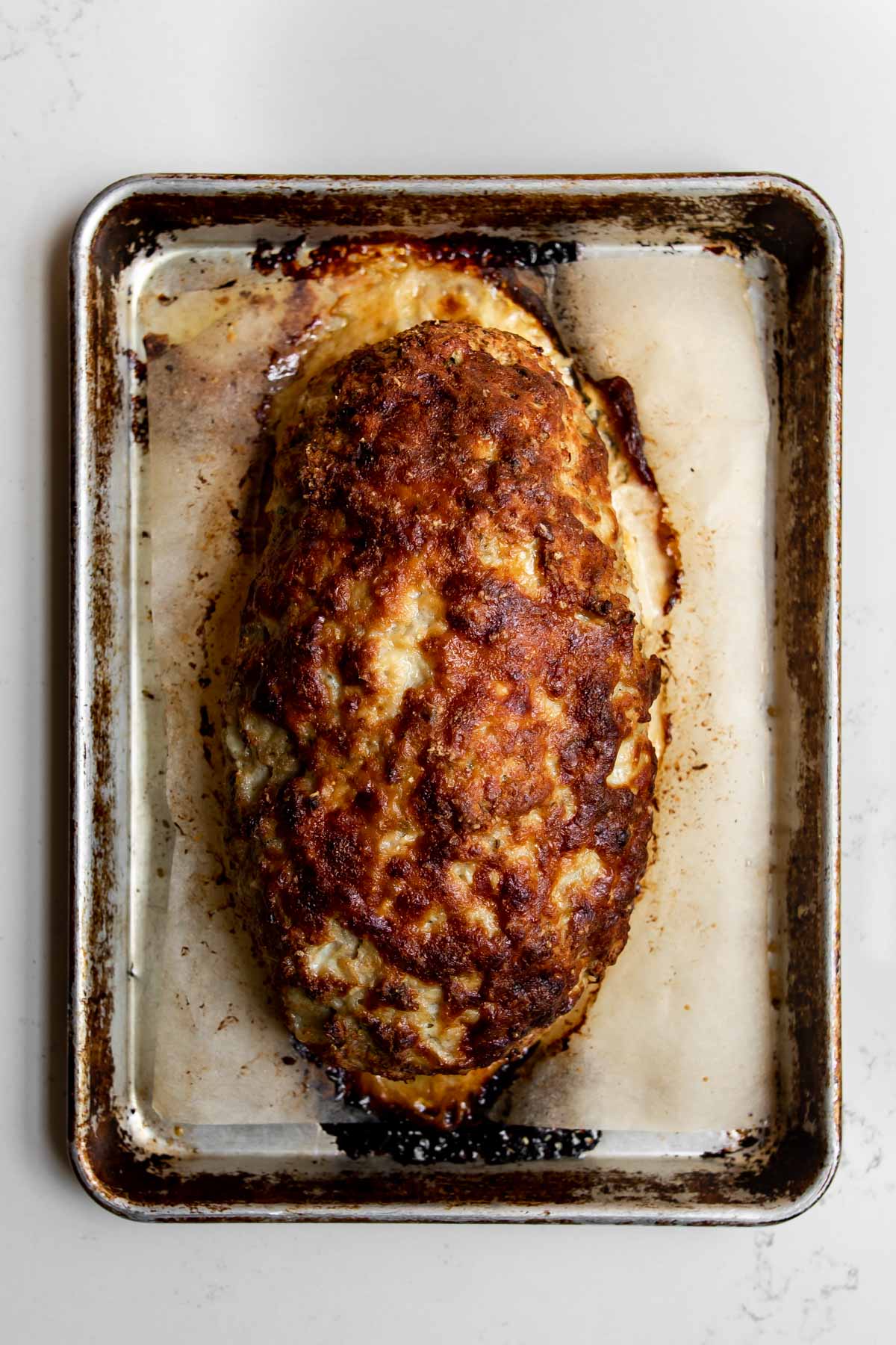 cooked ground chicken meatloaf on a sheet pan.