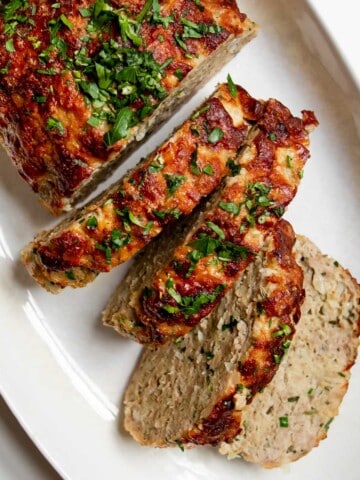 cooked ground chicken meatloaf cut into slices on a serving platter.