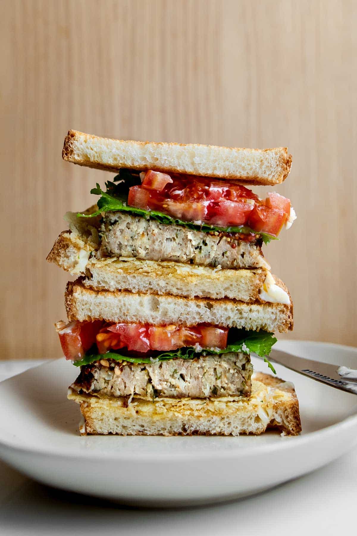 meatloaf sandwich cut in half and stacked on top of each other on a plate.