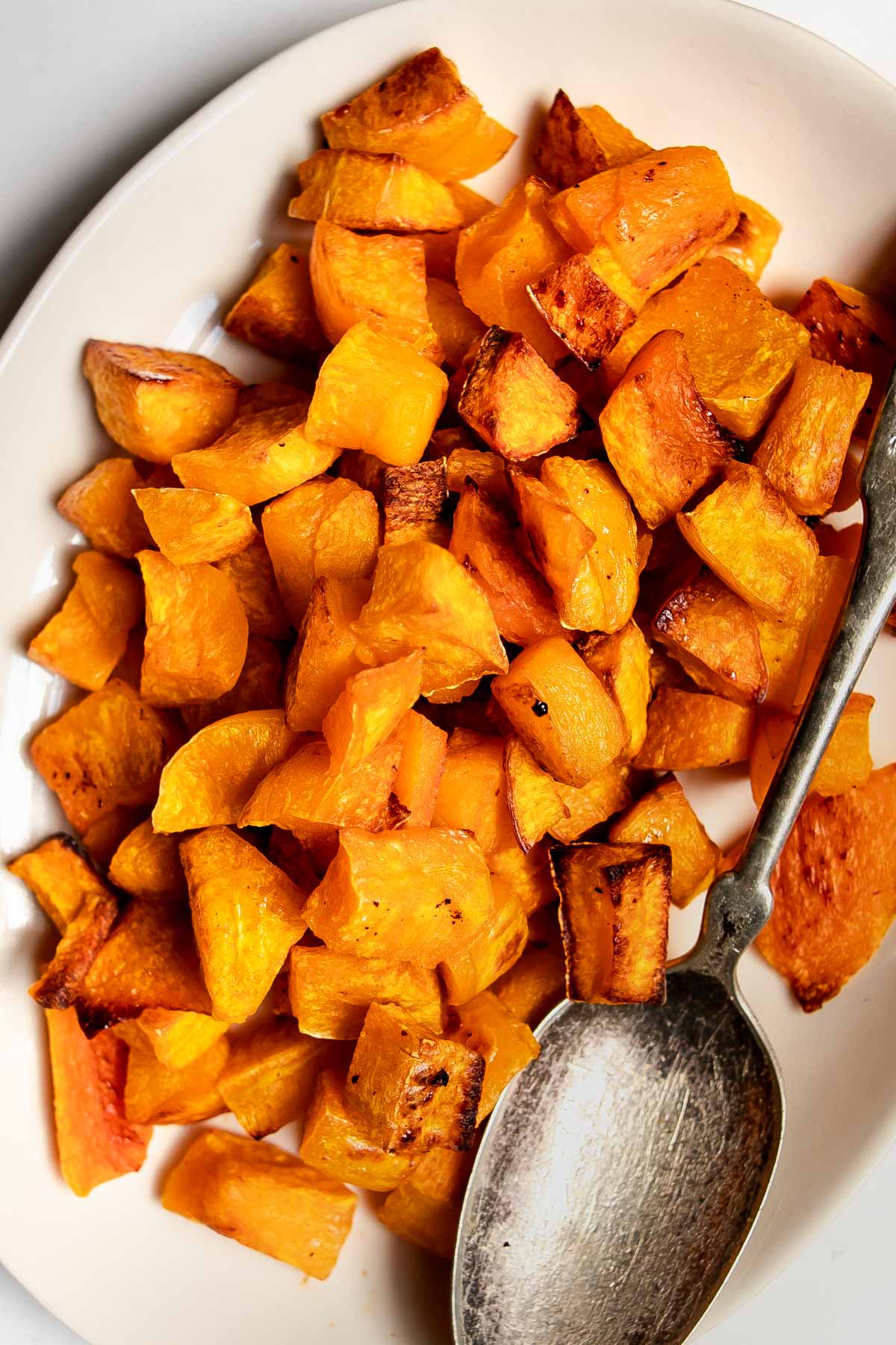 frozen roasted butternut squash on plate with a serving spoon.