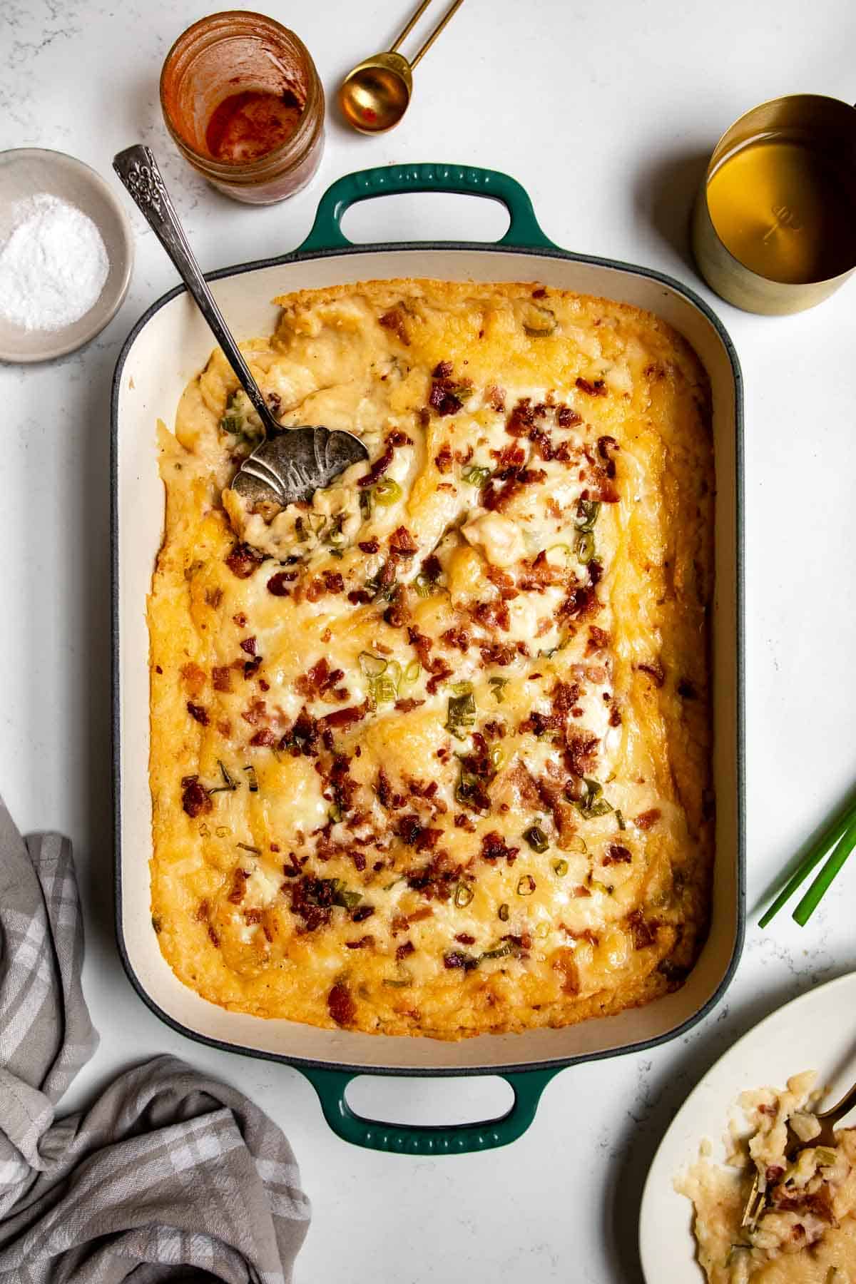 twice baked mashed potatoes in a casserole dish with ingredients around it.