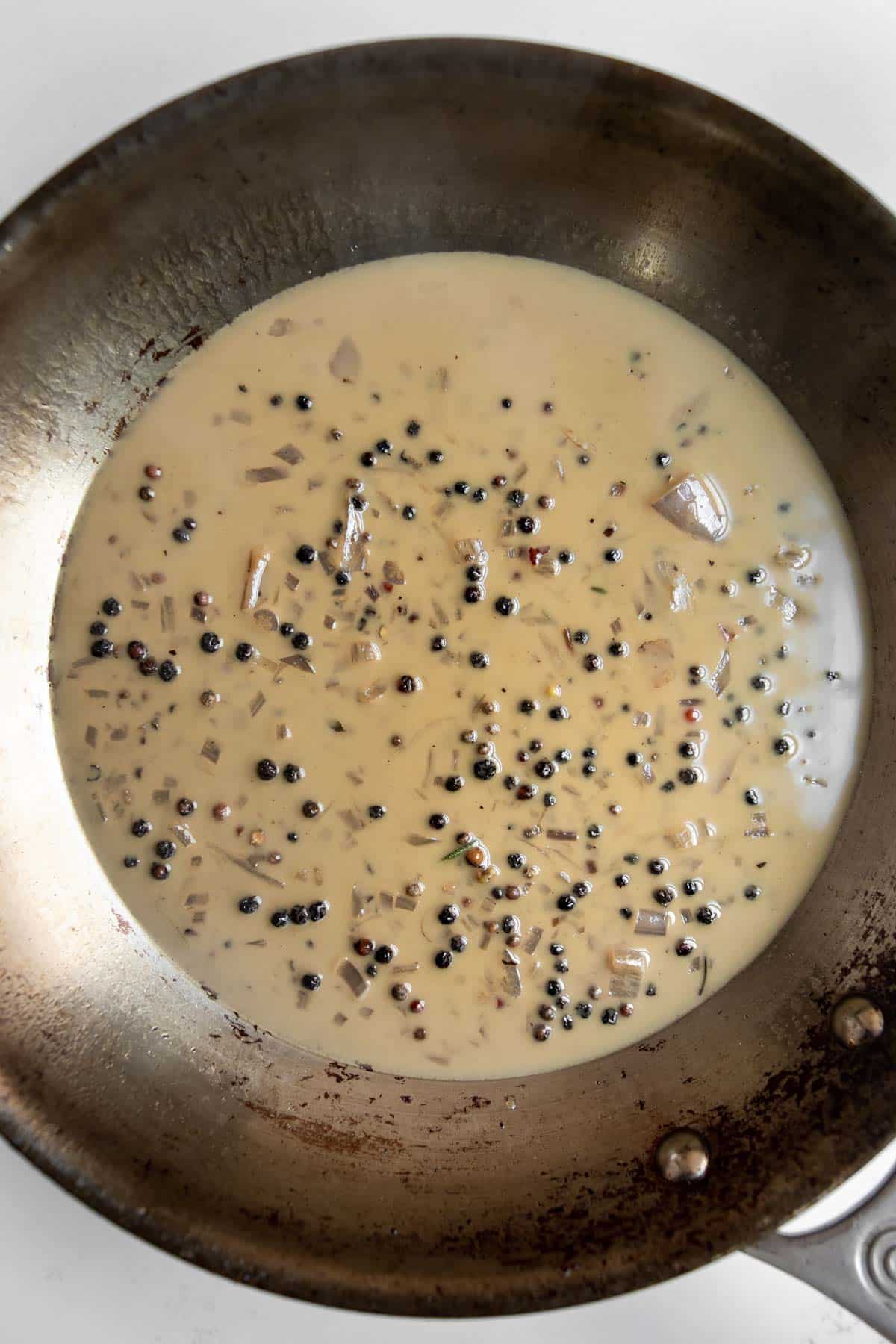 peppercorn sauce in a stainless steel pan