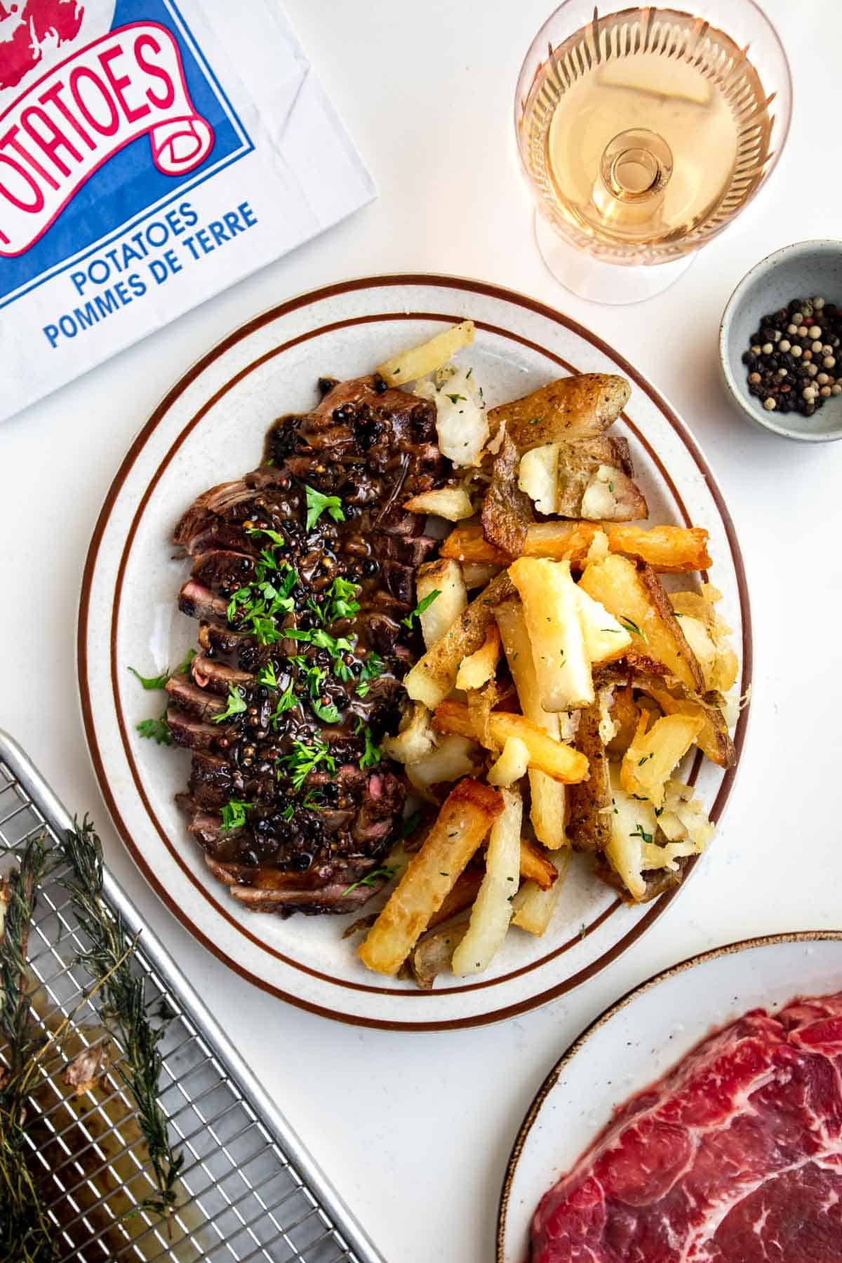 sirloin steak cut up on a plate with french fries